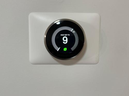 a black thermostat on a white wall at Modern 2 bedroom guest suite with AC in Calgary