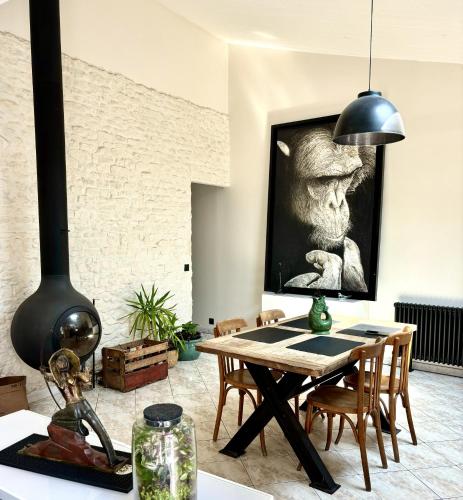 une salle à manger avec une table et une lampe noire dans l'établissement Maison au calme à l'orée d'un bois, proche plages, à Rivedoux-Plage