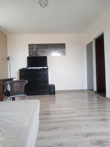 an empty white room with a bed and a dresser at Kawalerka 30 metrów in Siemiatycze