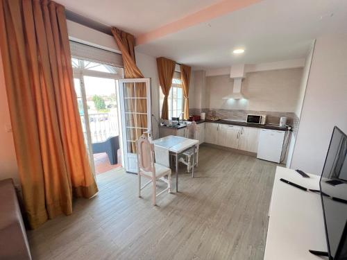 a living room with a table and a kitchen at Apartamentos Sanjuan in Porriño