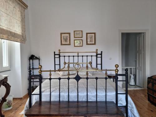 an antique bed in a bedroom with white walls at Abella Maison, Kythnos in Kithnos