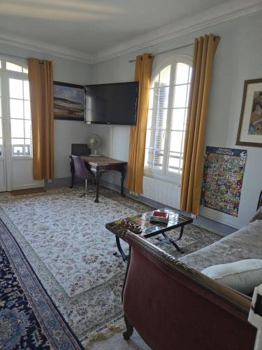 un salon avec un canapé et une table dans l'établissement Les Embruns - Le Port, à Deauville