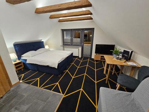 a bedroom with a bed and a desk with a computer at Richmount Apartamenty Karpacz in Karpacz