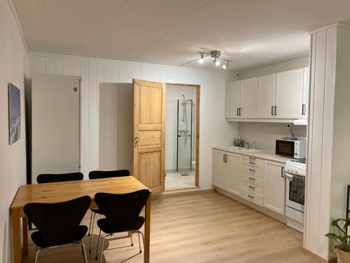 une cuisine avec une table et des chaises en bois dans l'établissement Modern apartment Kvaløya, à Kvaloysletta