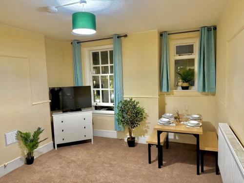 a living room with a tv and a table with a table at London Bridge 1-Bedroom Douglas building Entire Apartments in London
