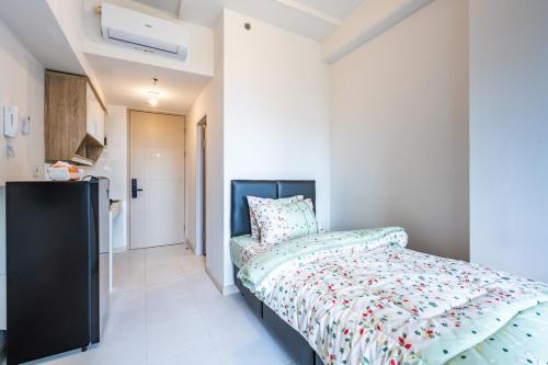 a bedroom with a bed with a colorful comforter at Modern Living in Tokyo Riverside Apartment PIK2 in Muara
