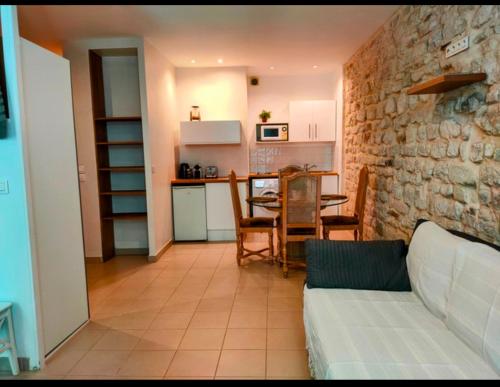 a living room with a couch and a table and a kitchen at Studio lumineux Paris centre - Chatelet in Paris