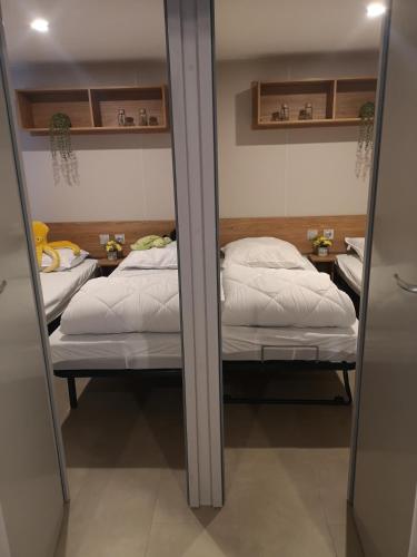 two twin beds in a room with mirrors at Chalet Hemelriekje in Gasselte