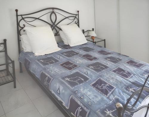 - un lit avec une couverture bleue et des oreillers blancs dans l'établissement Appartement confortable à Fréjus, 35 m² avec balcon agréable, à Fréjus