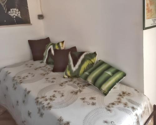 a bedroom with a bed with a comforter and pillows at Maison charmante à Sainte-Anne avec climatisation - 70 m² in Sainte-Anne