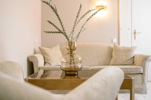 a living room with a couch and a vase on a table at A-ROSA Hotel Thurnher's Alpenhof in Zürs am Arlberg