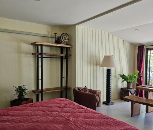 a bedroom with a bed and a chair and a clock at home stay pool villa chiang mai in Ban Thung Satong