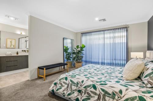 a bedroom with a large bed and a bathroom at Amberton Beachs Little Paradise By Swan Bnb in Alkimos