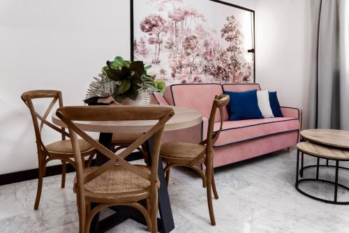 a living room with a couch and a table and chairs at Hotel Aptos Alejandra Home by Maxi Hoteles in Granada