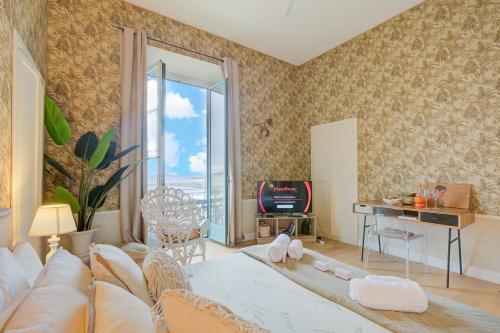 un salon avec un canapé, une table et une télévision dans l'établissement Casamare Sea View - Happy Rentals, à Menton