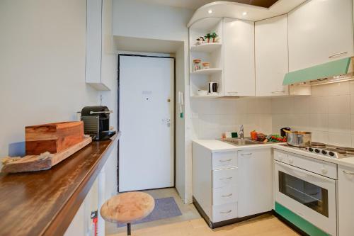 une cuisine avec des armoires blanches et un comptoir dans l'établissement Casamare Sea View - Happy Rentals, à Menton