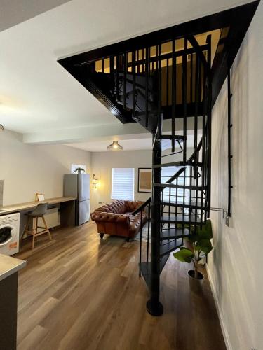 a living room with a spiral staircase in a house at Central Industrial Chic 2-Bedroom Flat in Crewe