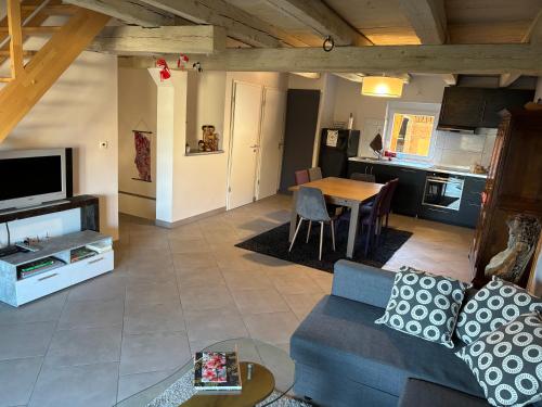 a living room with a blue couch and a kitchen at La grange de Sophie in Berstett