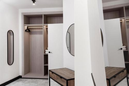 a walk in closet with a wooden bench and a mirror at Hotel Aptos Alejandra Home by Maxi Hoteles in Granada