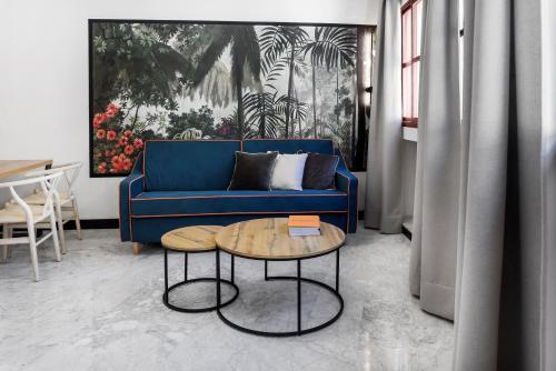 a living room with a blue couch and a table at Hotel Aptos Alejandra Home by Maxi Hoteles in Granada