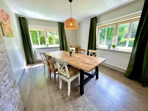 ein Esszimmer mit einem Holztisch und Stühlen in der Unterkunft HIRSCH Gretel Ferienhaus - Garten mit Grill - Wald in Altenau