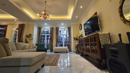 a living room with a couch and a tv at El Villa Forest Bogor in Bogor