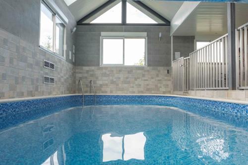 - une piscine dans une maison avec une piscine bleue dans l'établissement Villa des champs, à Villers-sous-Foucarmont