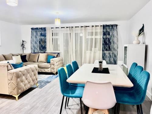 a living room with a table and blue chairs at Stunning Five Bedroom Holiday Home in Chartham Canterbury with Hot Tub in Chartham
