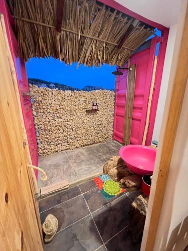 a bathroom with a pink toilet and a wall at Mojarra Beach Casa Privada-Santa Veronica in Salina de Rey