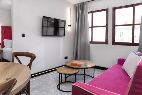 a living room with a purple couch and a table at Hotel Aptos Alejandra Home by Maxi Hoteles in Granada