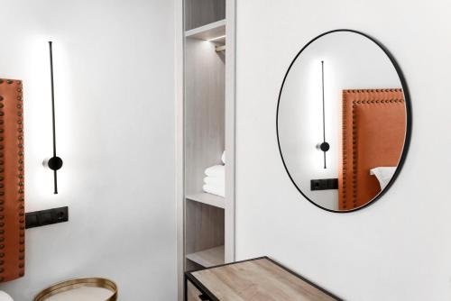 a bathroom with a mirror and a wooden table at Hotel Aptos Alejandra Home by Maxi Hoteles in Granada