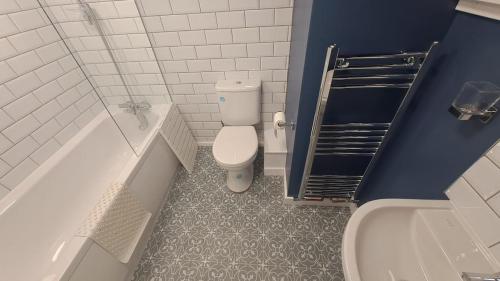 ein Badezimmer mit Toilette, Badewanne und Waschbecken in der Unterkunft Charming Four Person Malthouse Apartment in Much Wenlock