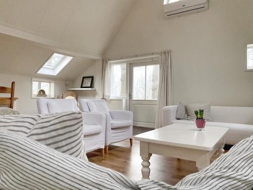 a living room with white furniture and a white table at Boerderijhuisje 22 - Landelijk logeren bij Sneek in Loënga