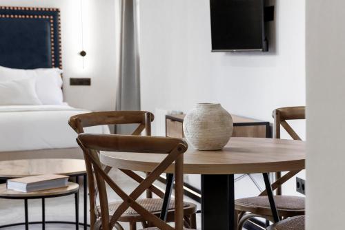 a room with a table and chairs and a bed at Hotel Aptos Alejandra Home by Maxi Hoteles in Granada