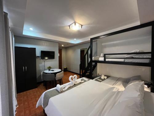 a bedroom with a bed and a bunk bed at Rangya Hotel in Tagaytay