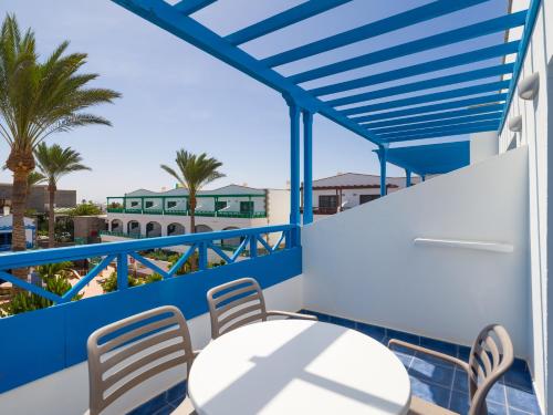 a balcony with a table and chairs and palm trees at Hotel Mirador Papagayo by LIVVO in Playa Blanca