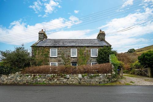 an old stone house on the side of a road at Ty Mawr Llanfair in Llanfair