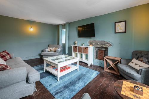 a living room with a couch and a fireplace at Ty Mawr Llanfair in Llanfair