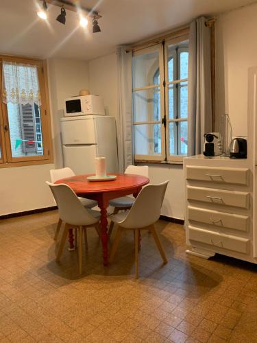 Una cocina con mesa y sillas y un refrigerador. en Maison familiale des remparts, en Colmars