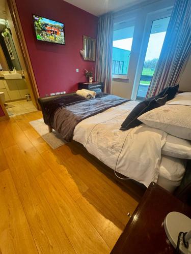 a bedroom with two beds and a tv on the wall at Hazelwood Country House in Adare