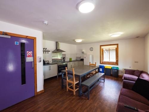 a kitchen and living room with a table and a couch at YHA London Lee Valley in Cheshunt