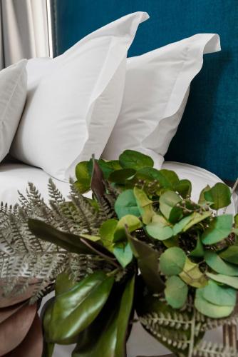 a plant sitting on a plate next to a pillow at Hotel Aptos Alejandra Home by Maxi Hoteles in Granada