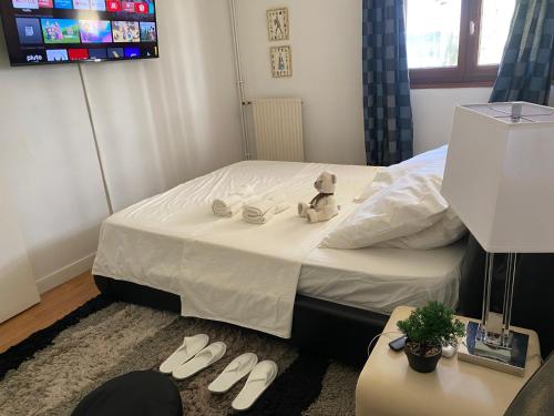 a bedroom with a bed with a teddy bear sitting on it at Appt 3 pièces Suresnes in Suresnes