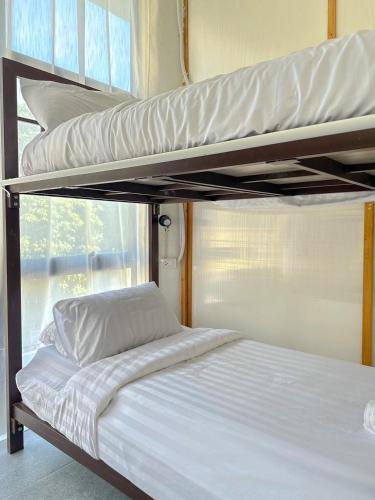 a bedroom with two bunk beds and a window at Shared Room Megun in Ban Bang Phlat