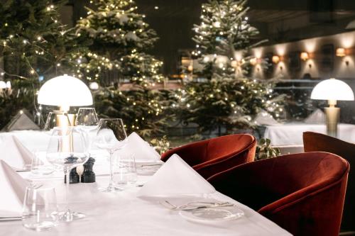 a dining table with wine glasses and christmas trees at A-ROSA Hotel Thurnher's Alpenhof in Zürs am Arlberg