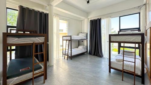a room with three bunk beds and a window at Shared Room Megun in Ban Bang Phlat