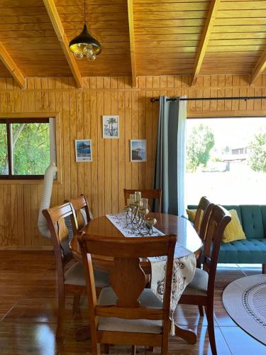 a dining room with a wooden table and chairs at Comodidad y Hermosa Vista Volcán in Melipeuco