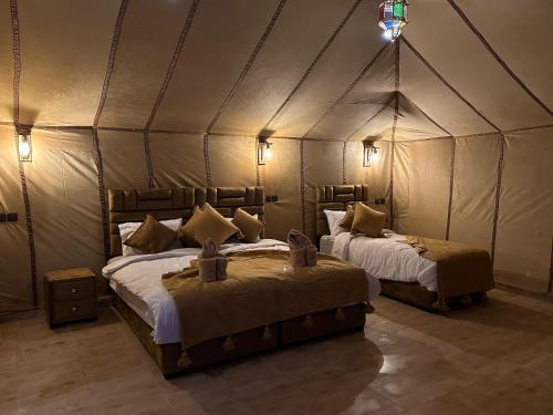 a bedroom with two beds in a tent at Milagro Luxury camp & AC in Merzouga