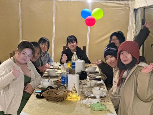 a group of people sitting at a dinner table at Milagro Luxury camp & AC in Merzouga