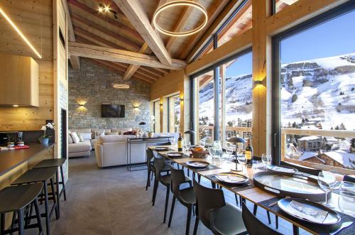 une salle à manger avec une longue table avec des chaises dans l'établissement Odalys Chalet Le Lynx, à Les Deux Alpes